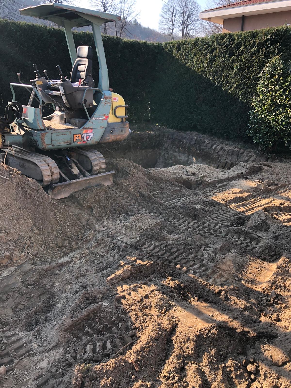 Escavatore al lavoro nello scavo per la piscina